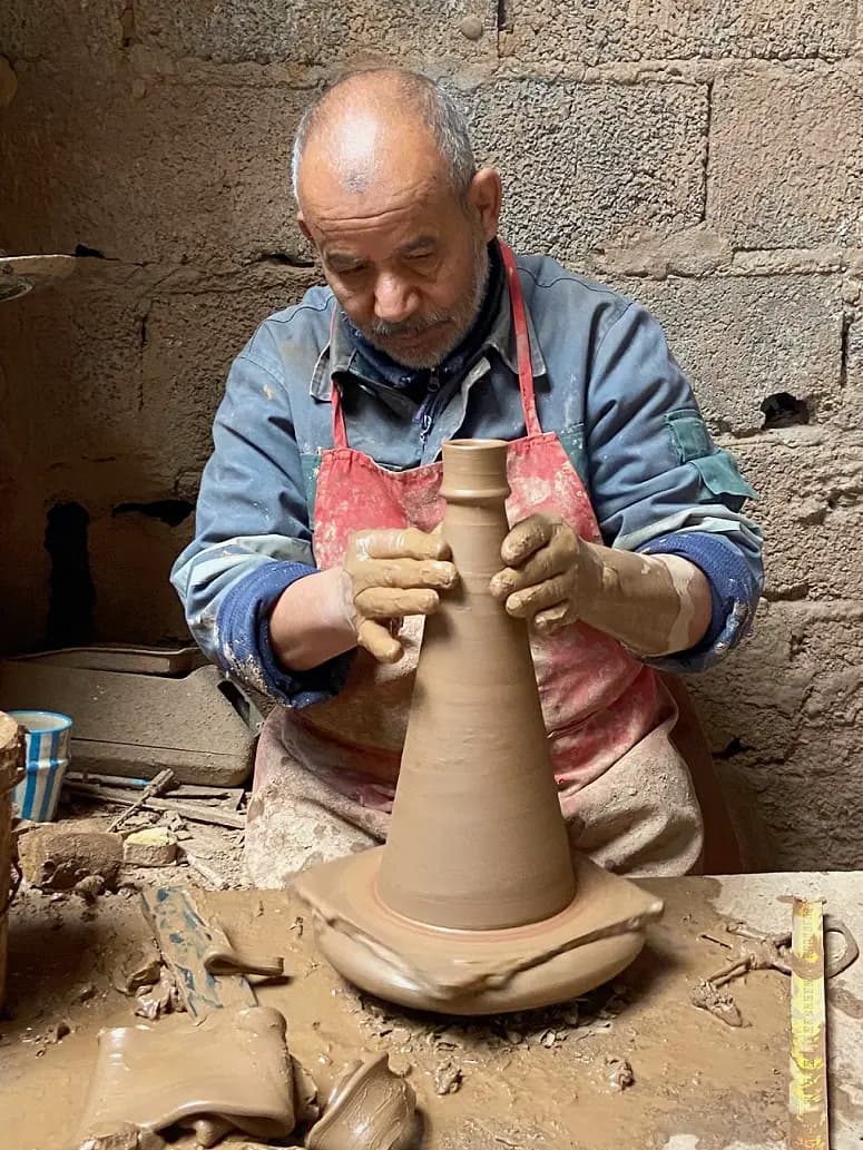 Atelier poterie Marrakech : participant centrant l'argile sur le tour