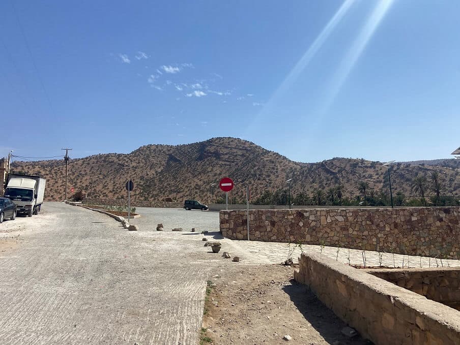Parking devant l'oasis de Tiout avec une vue impressionnante sur les montagnes