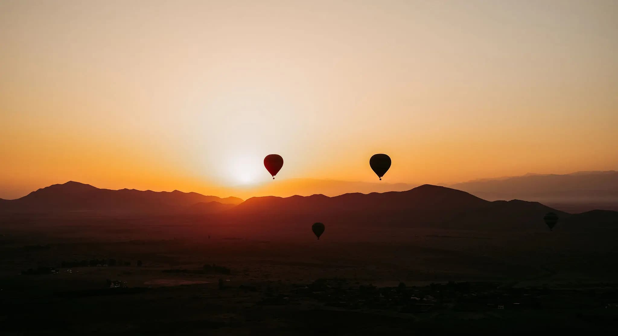 Vol en montgolfiere dans le ciel avec vue sur les montagnes au lever du soleil agadir